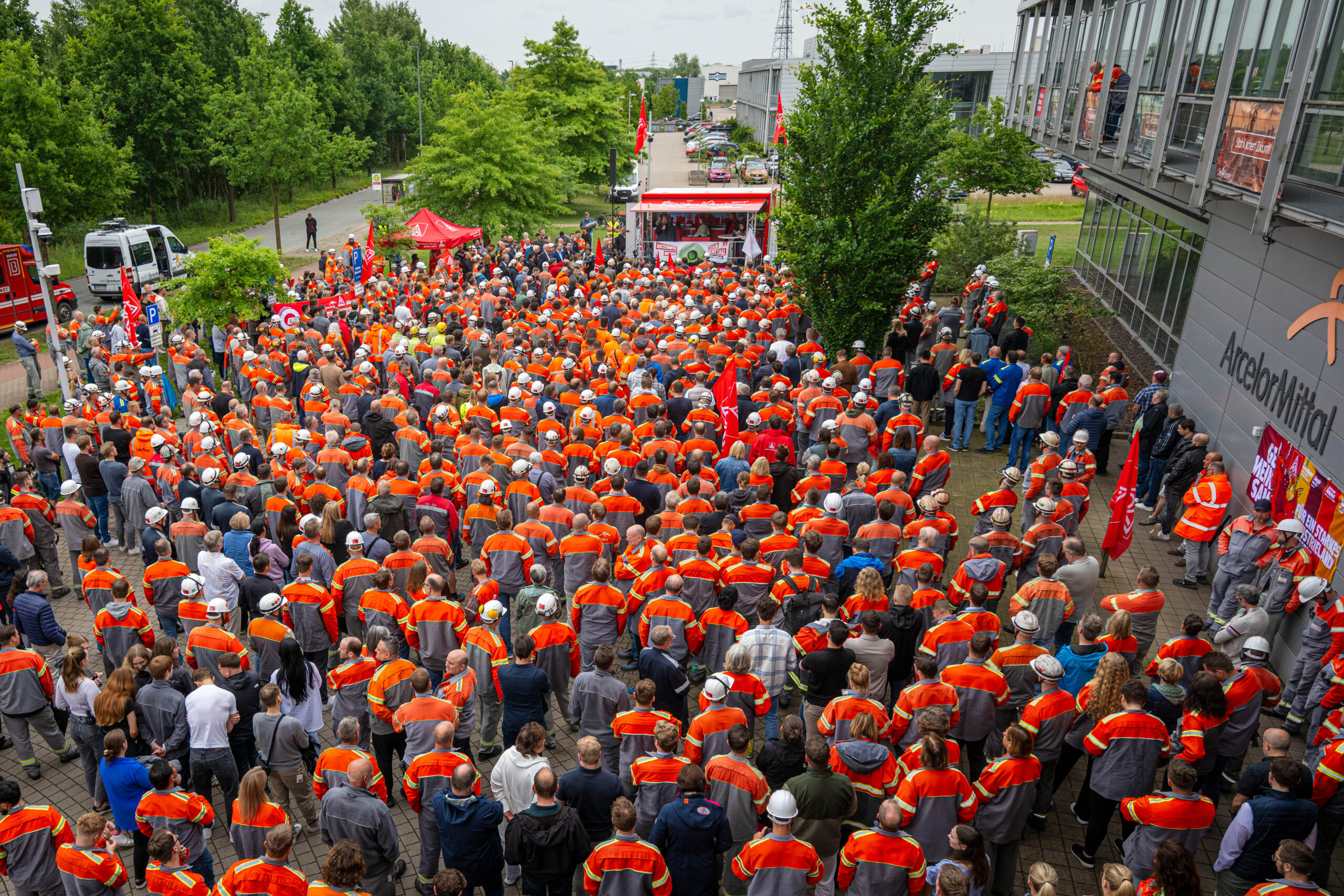 Viele Arbeiter stehen bei der Kundgebung in orange-grauen Uniform