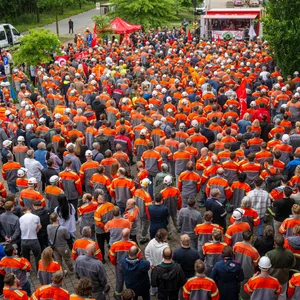 Viele Arbeiter stehen bei der Kundgebung in orange-grauen Uniform