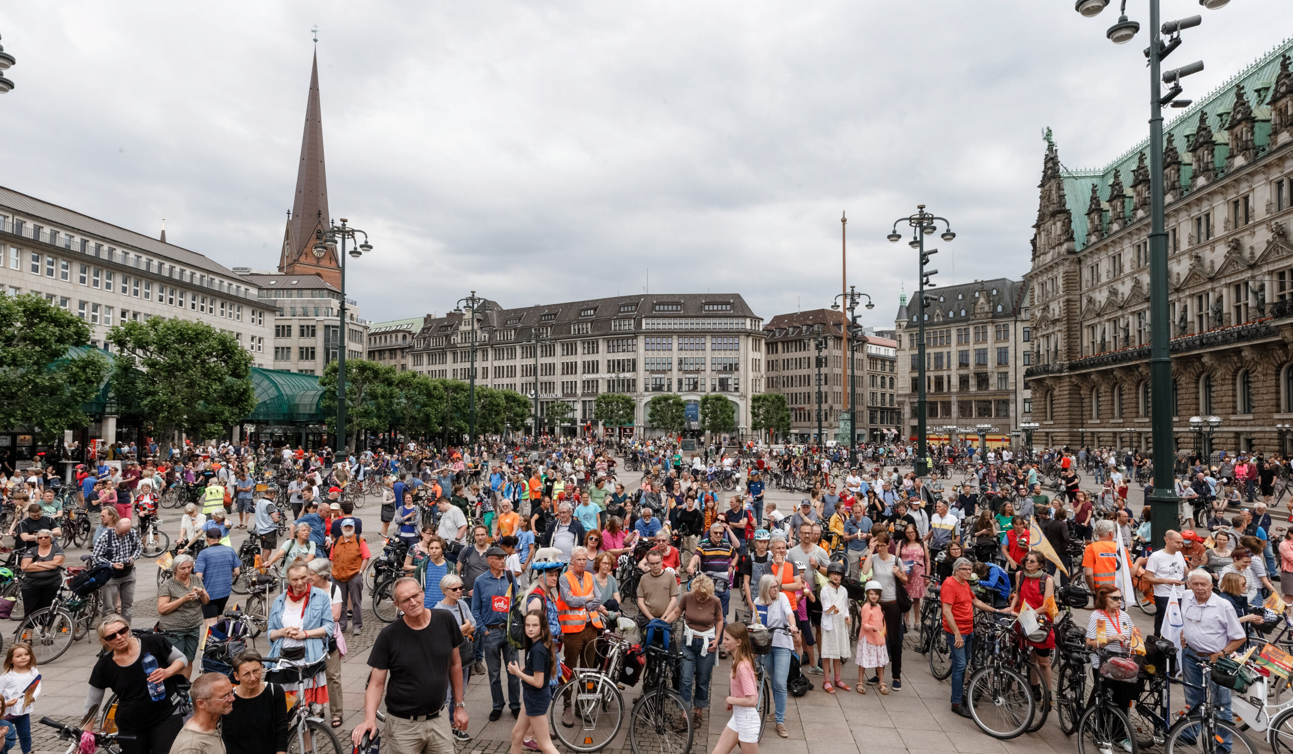 Menschenmenge mit Fahrrädern vor dem Rathaus
