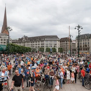 Menschenmenge mit Fahrrädern vor dem Rathaus