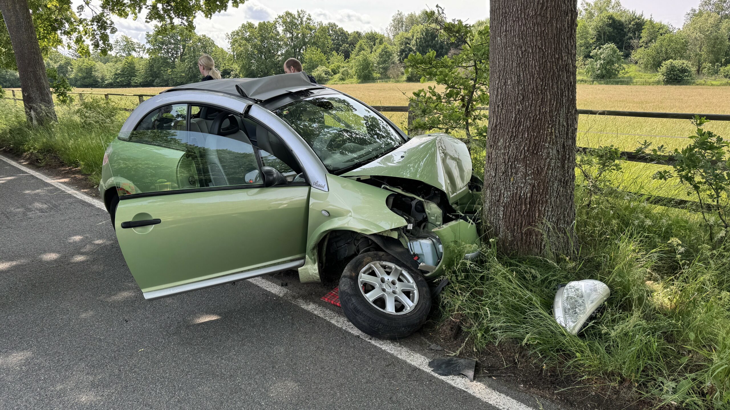 Ein kaputtes Auto vor einem Baum