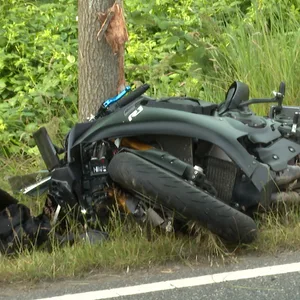 Motorrad liegt neben der Fahrbahn.