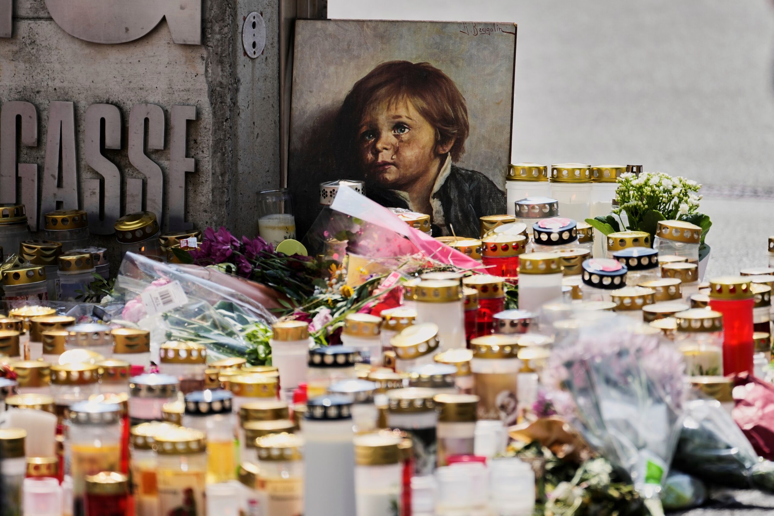 Kerzen, Blumen und ein Bild am Eingang der Schule in Graz, in der ein ehemaliger Schüler zwei Tage zuvor das Feuer eröffnet hat