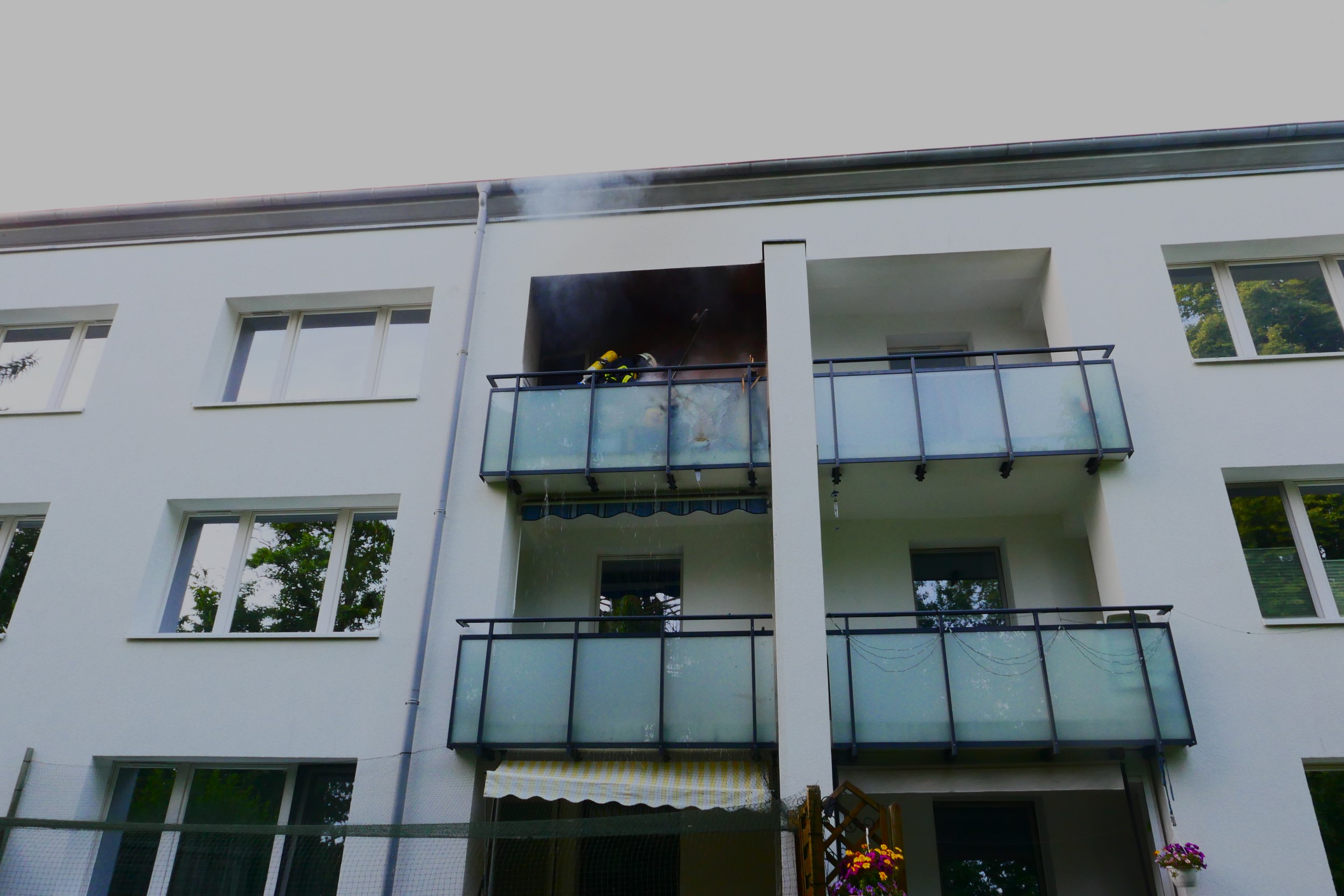Feuerwehrleute löschen den Balkonbrand in Hamburg-Lohbrügge.