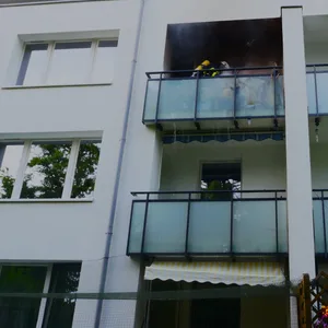 Feuerwehrleute löschen den Balkonbrand in Hamburg-Lohbrügge.