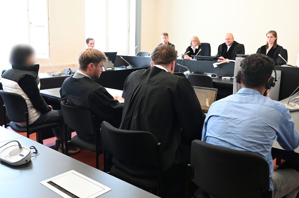 Die Angeklagten (l. und r.) sitzen mit ihren Anwälten Tom Bühe (2.v.r.) und Moritz von Bülow (3.v.r.) im Strafjustizgebäude in Hamburg.