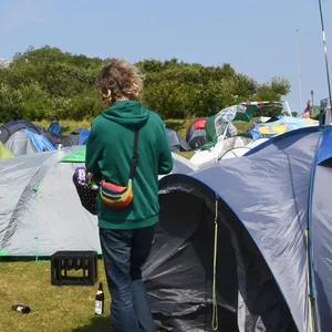Zelte und eine schwarz-rote Flagge einer Antifagruppe im Punk-Protestcamp auf der Festwiese.