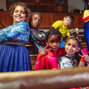 Acht Kinder der Aufführung „Super Wrestling“ stehen und sitzen im Ring.
