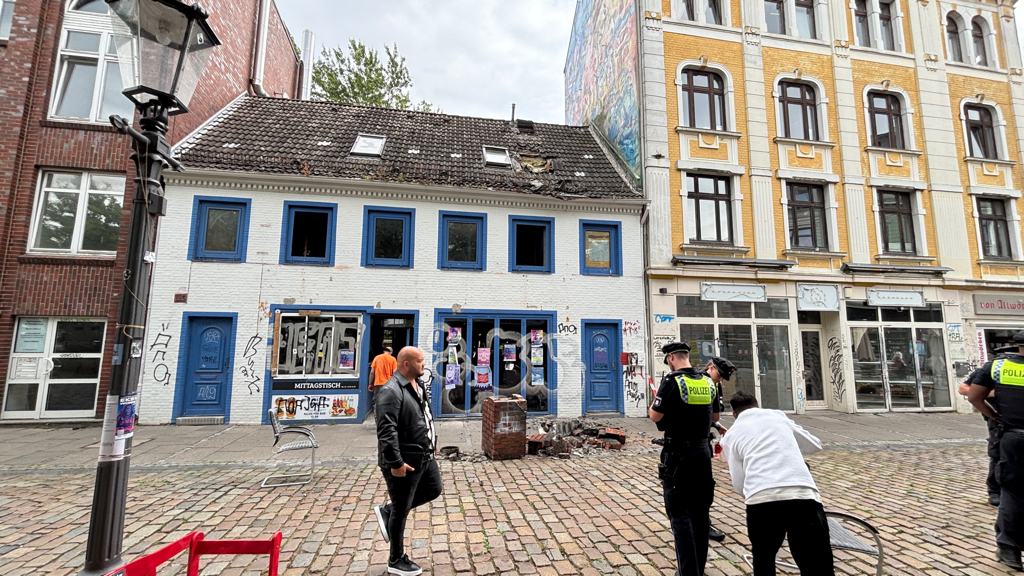 Weißes Haus, davor liegt ein Schornstein