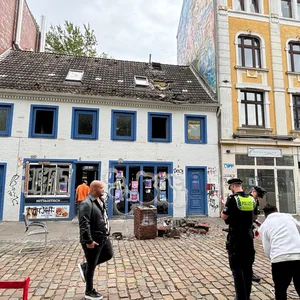 Weißes Haus, davor liegt ein Schornstein