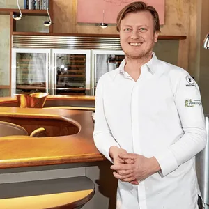 Kevin Fehling lehnt an einer Holzbar.