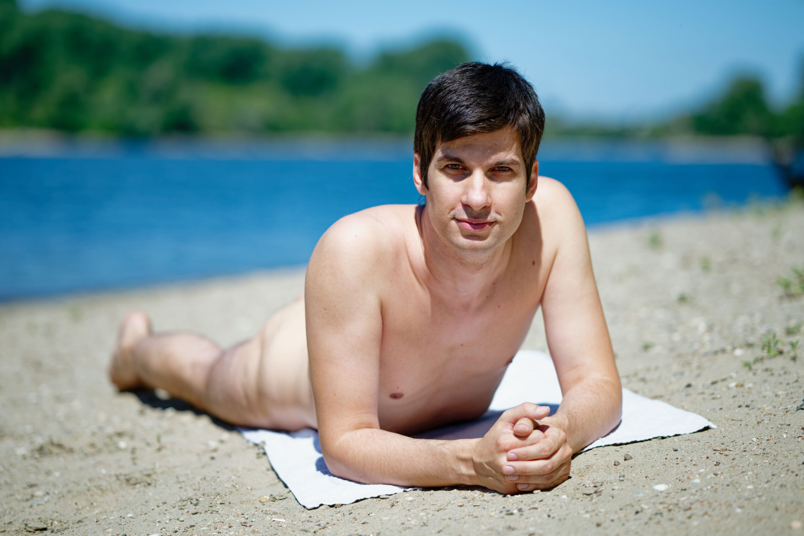 Mannheims Stadtrat Julien Ferrat liegt nackt am Strand.
