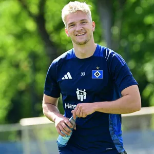 Noah Katterbach lächelt beim HSV-Training in die Kamera