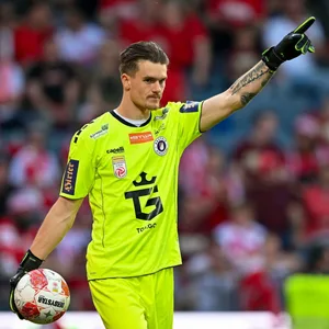 Simon Spari hebt einen Finger in die Luft und hält den Ball in der Hand