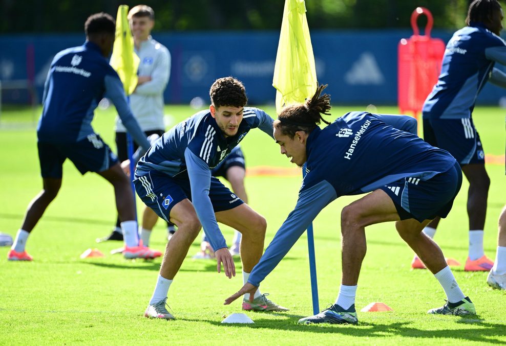 Daniel Elfadli und Yussuf Poulsen bücken sich nach einem Trainingshütchen.