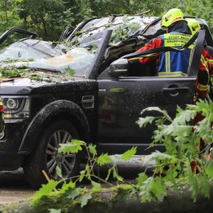 Feuerwehrkräfte stehen an dem verunfallten Auto.