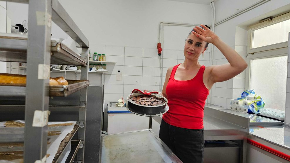 Frau mit Kuchen vor einem Backofen