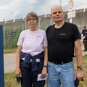 Ein Mann und eine Frau vor einem Gefängnis