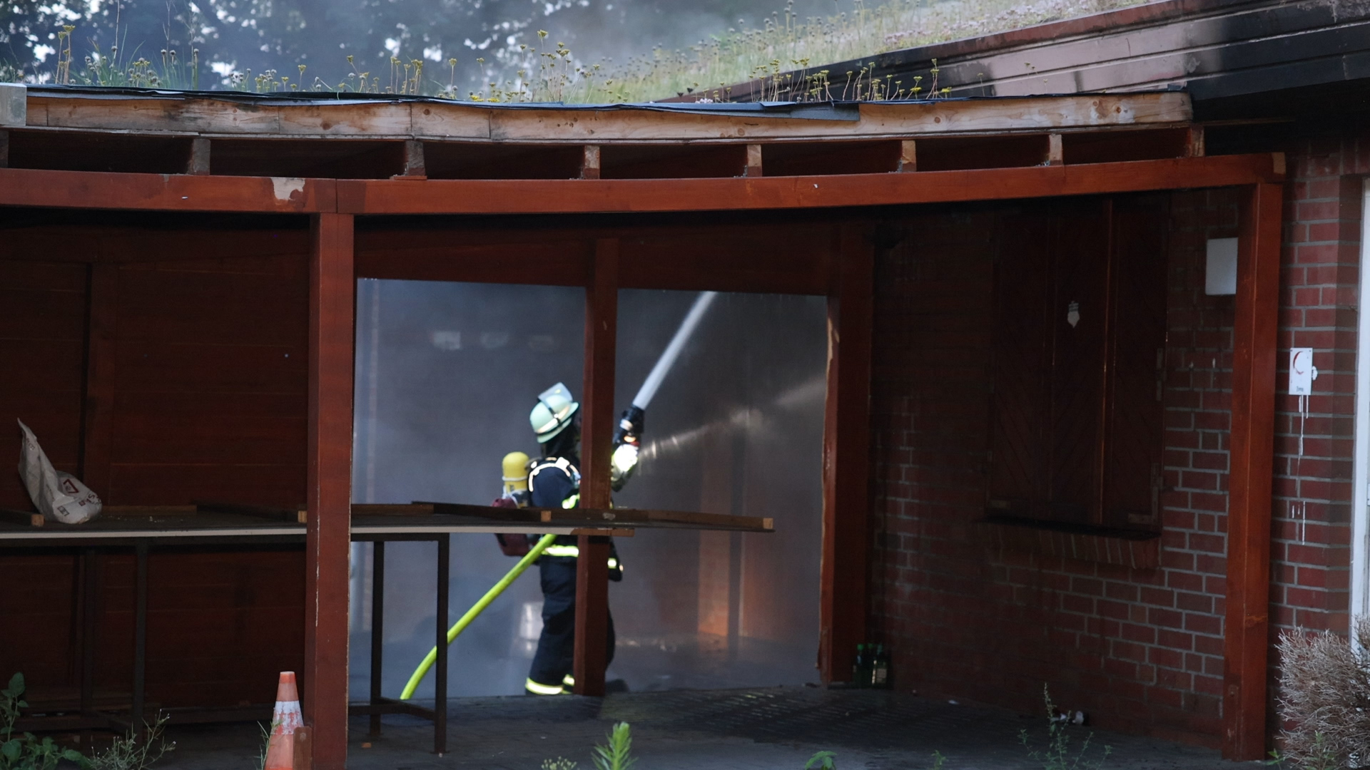 Ein Retter bekämpft die Flammen mit Wasser.