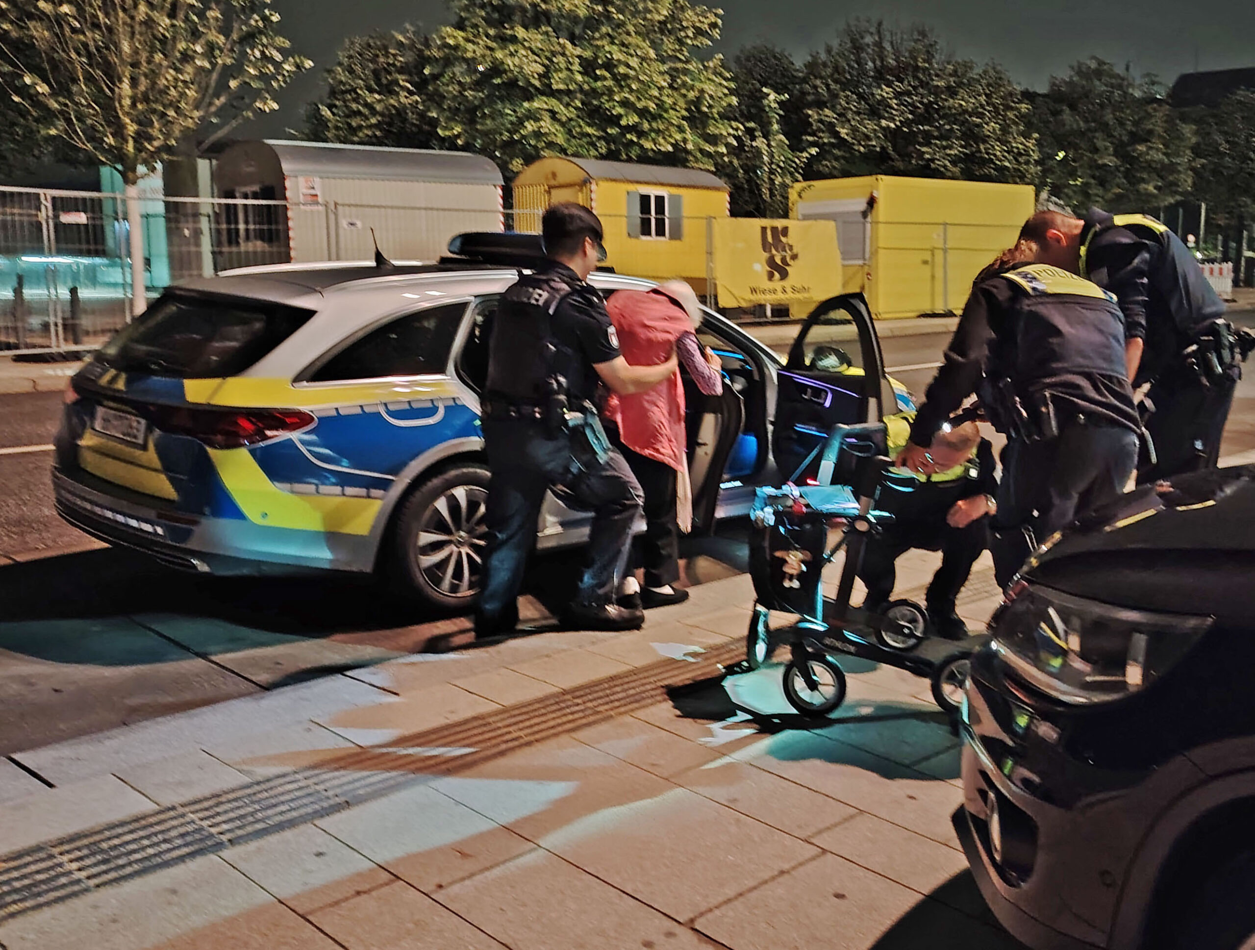 Alte Dame steigt in ein Polizeiauto