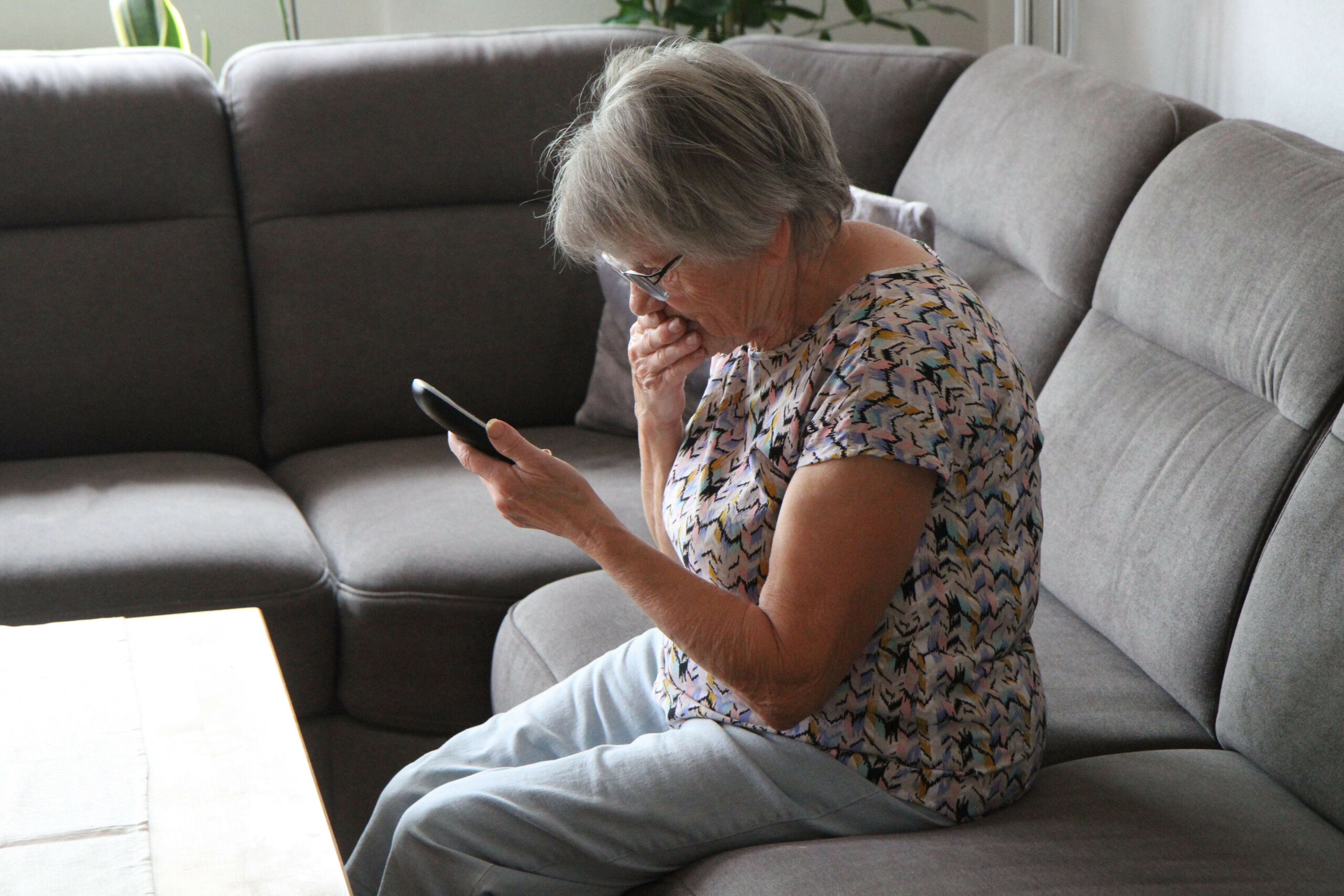 Frau liest eine beunruhigende Mail auf ihrem Smartphone.