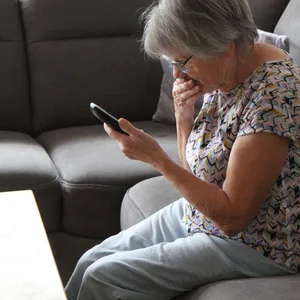 Frau liest eine beunruhigende Mail auf ihrem Smartphone.