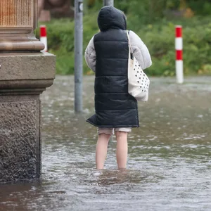 Eine Frau steht knöcheltief im Wasser