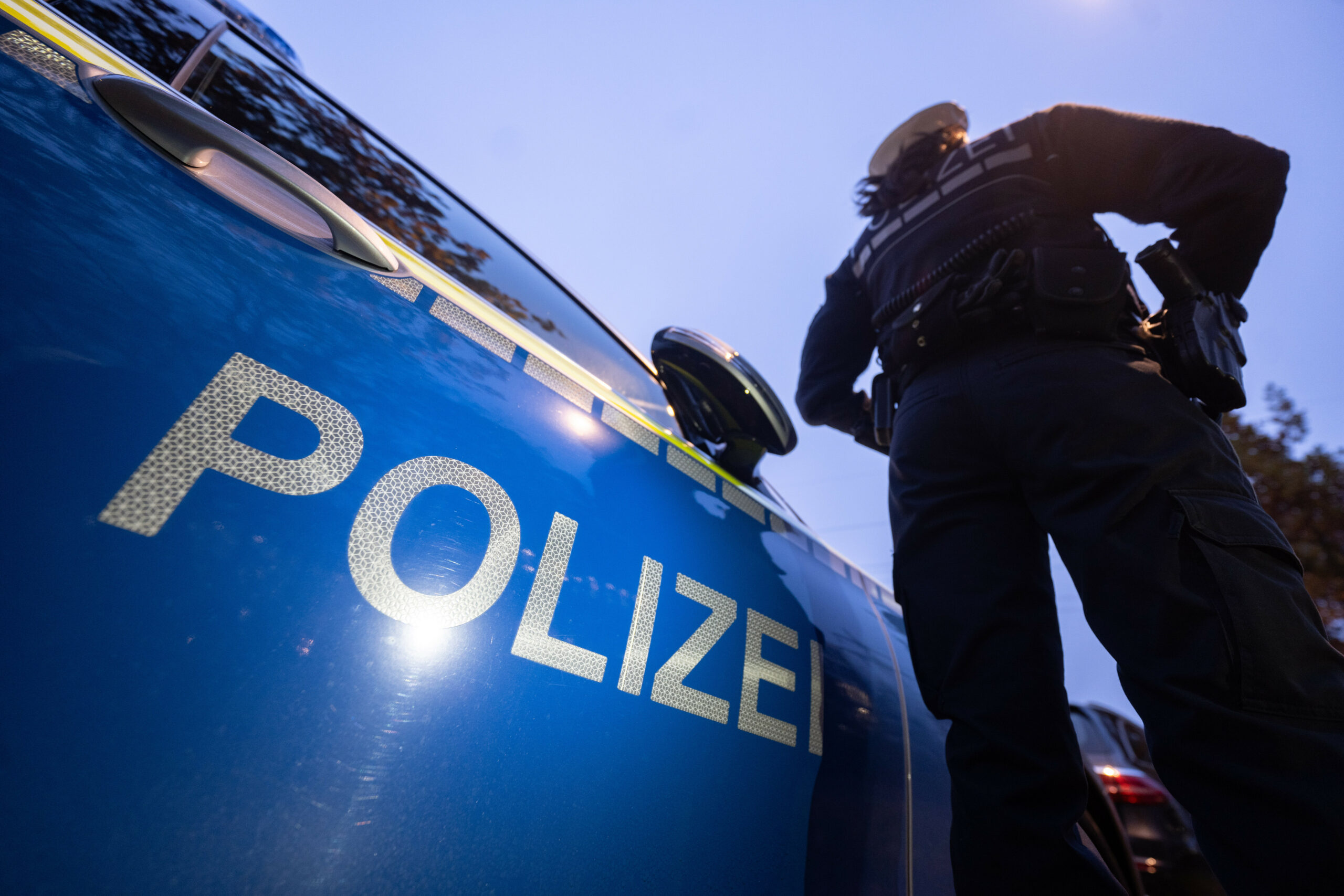 Eine Polizistin steht neben einem Polizeifahrzeug. (Symbolbild)