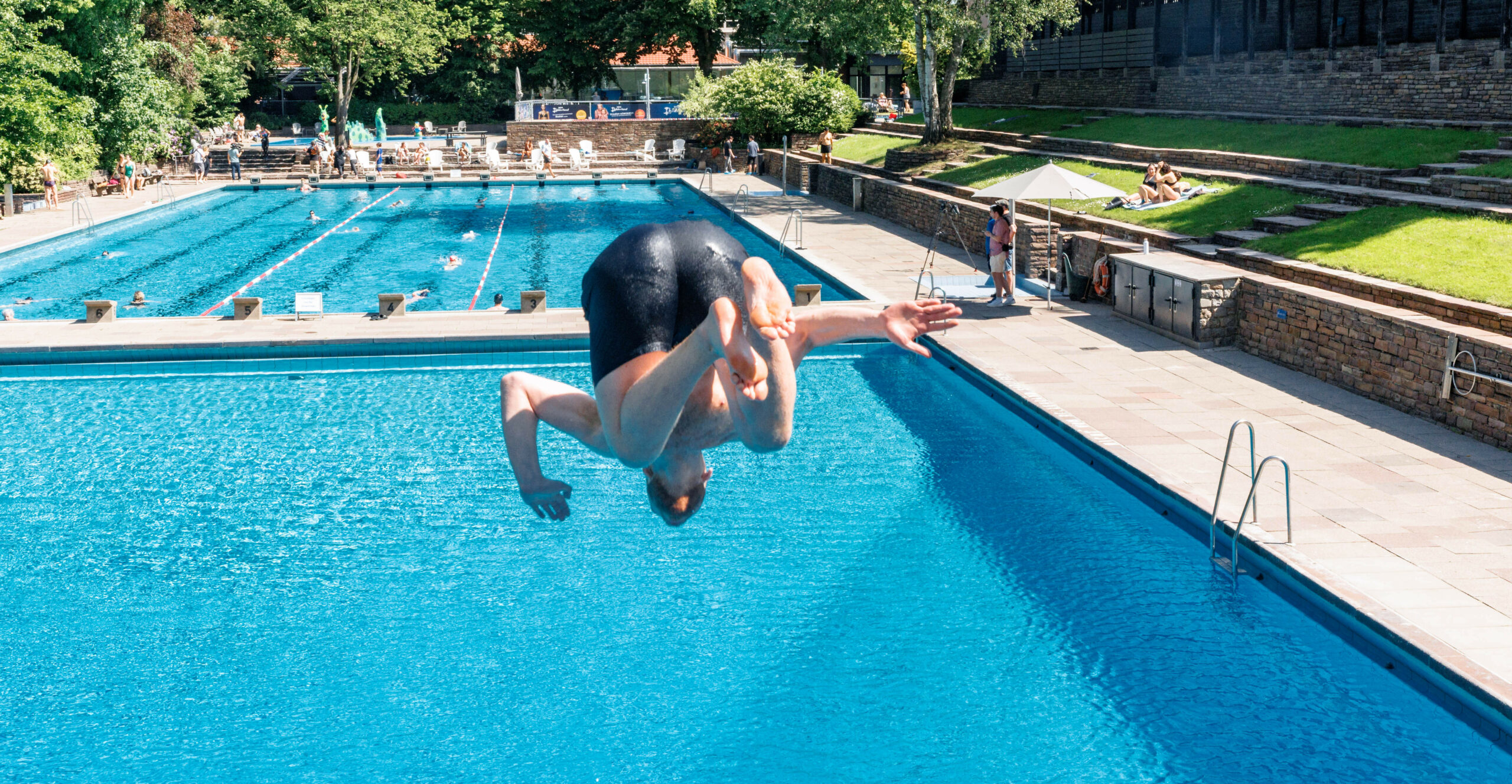 Junge springt in Freibad-Becken
