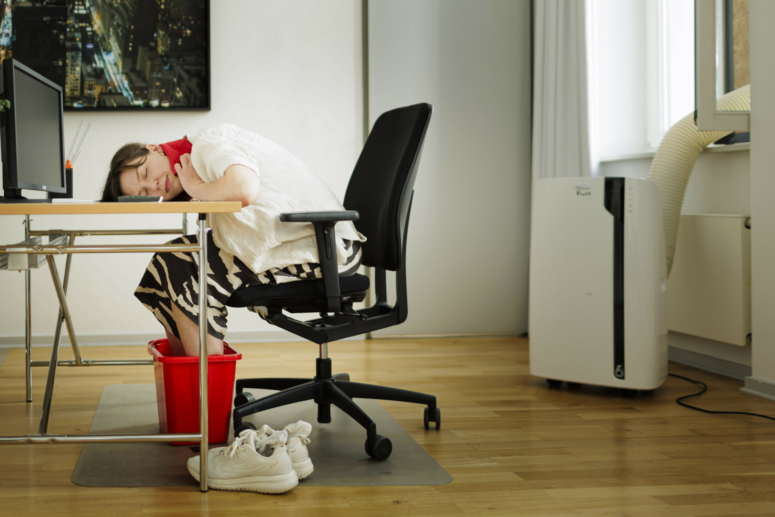 Eine Frau sitzt bei starker Hitze in einem Büro (Symbolbild).