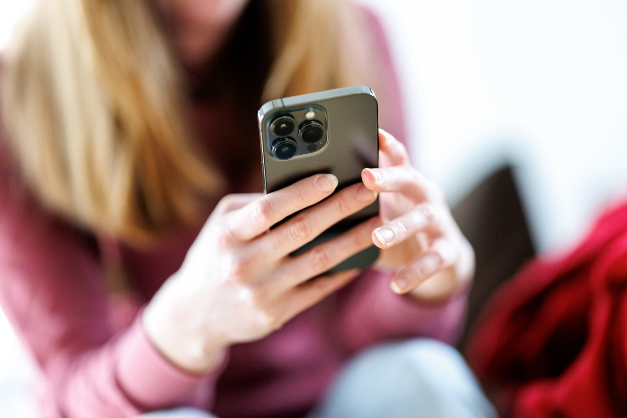 Eine junge Frau benutzt ein Smartphone.
