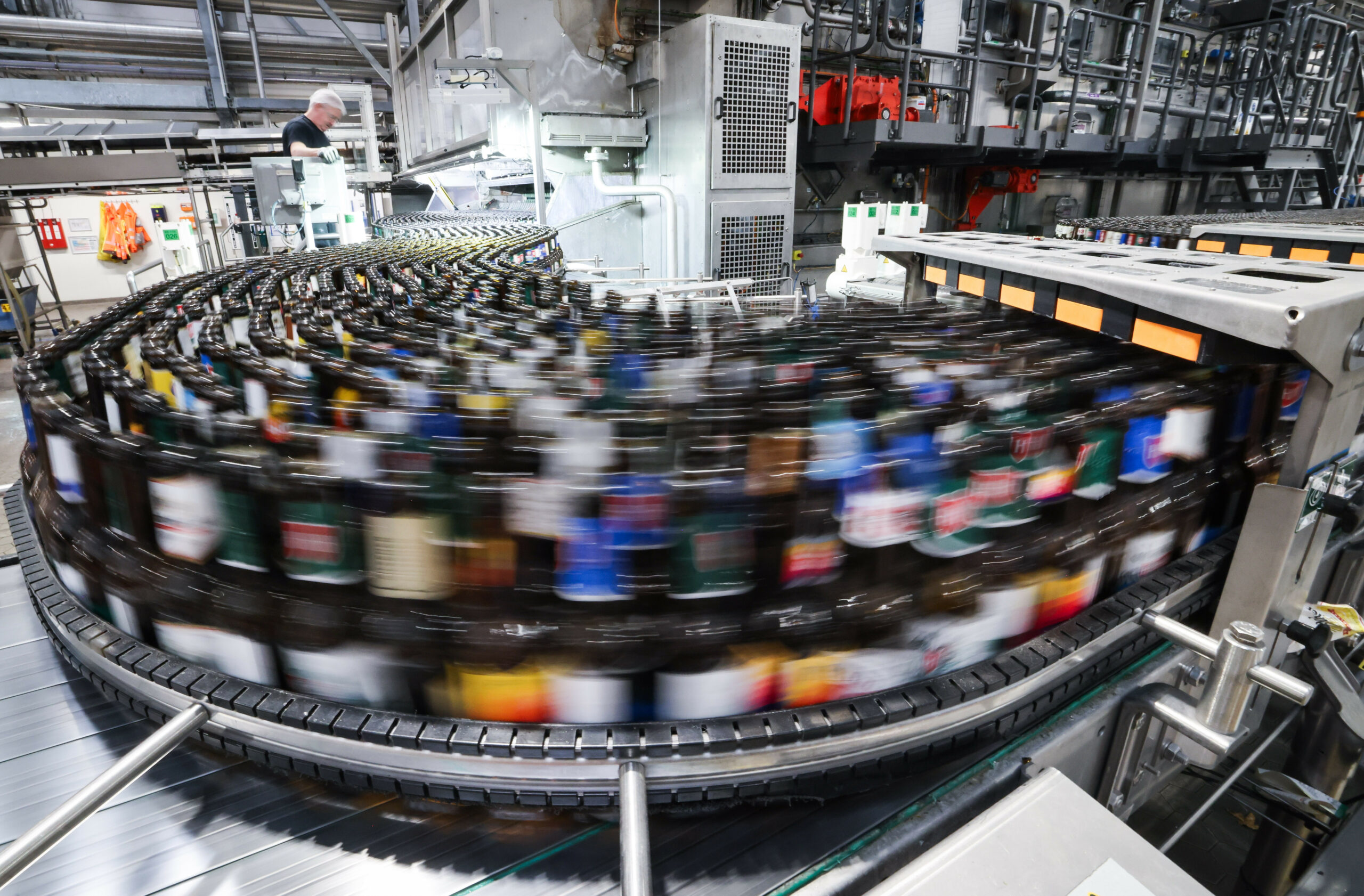 Flaschen laufen durch eine Anlage in einer Brauerei (Symbolbild).
