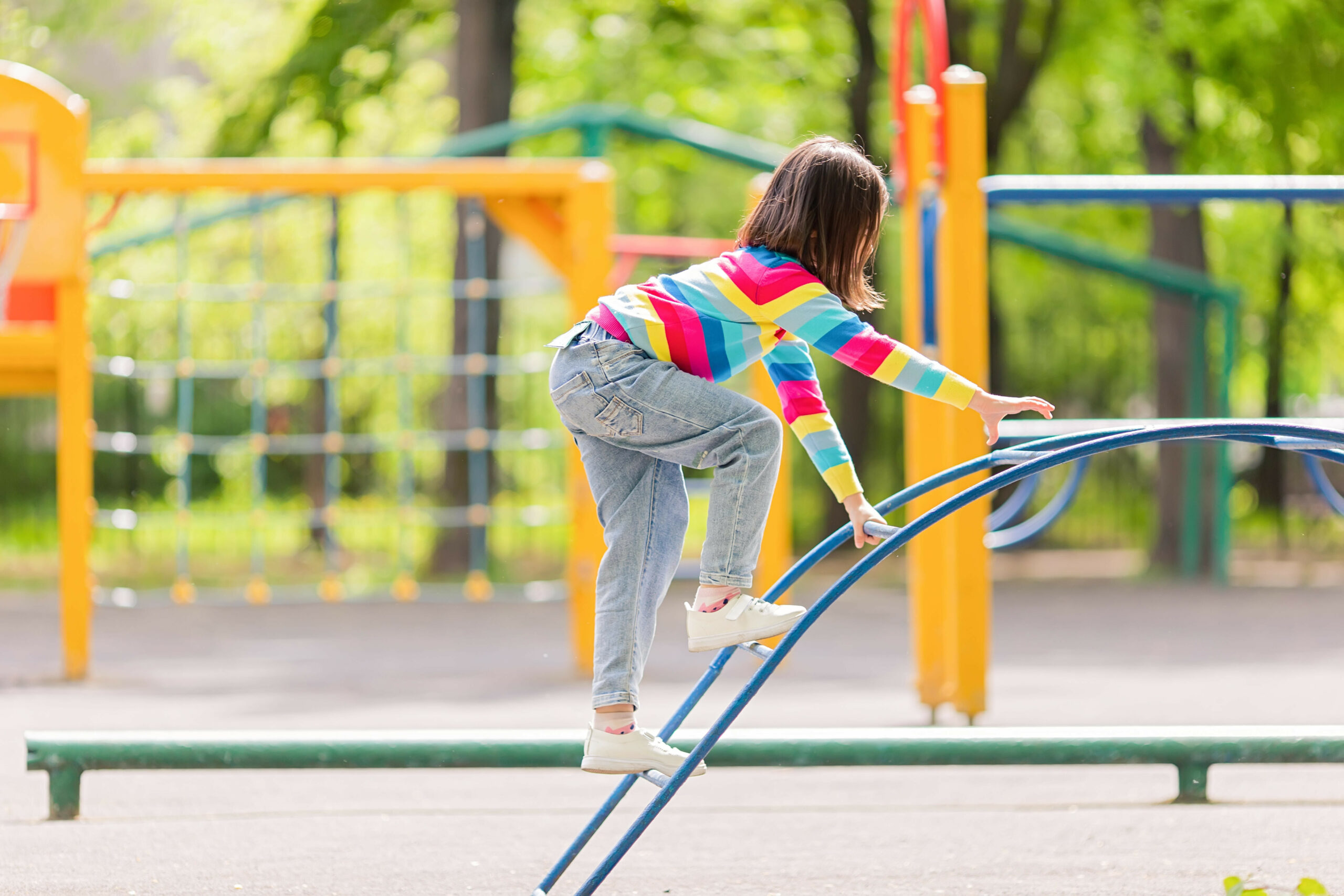 Kind klettert auf einem Spielplatz
