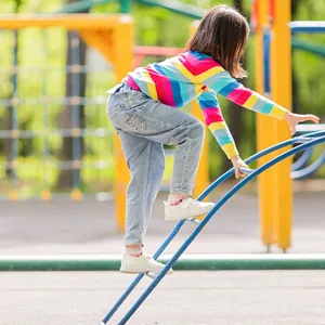 Kind klettert auf einem Spielplatz