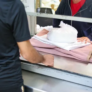 Ein Migrant bekommt in einer Zentralen Aufnahmeeinrichtung für Asylbewerber die Erstausstattung an Besteck, Bettwäche und Hygieneartikeln überreicht. (Symbolbild)