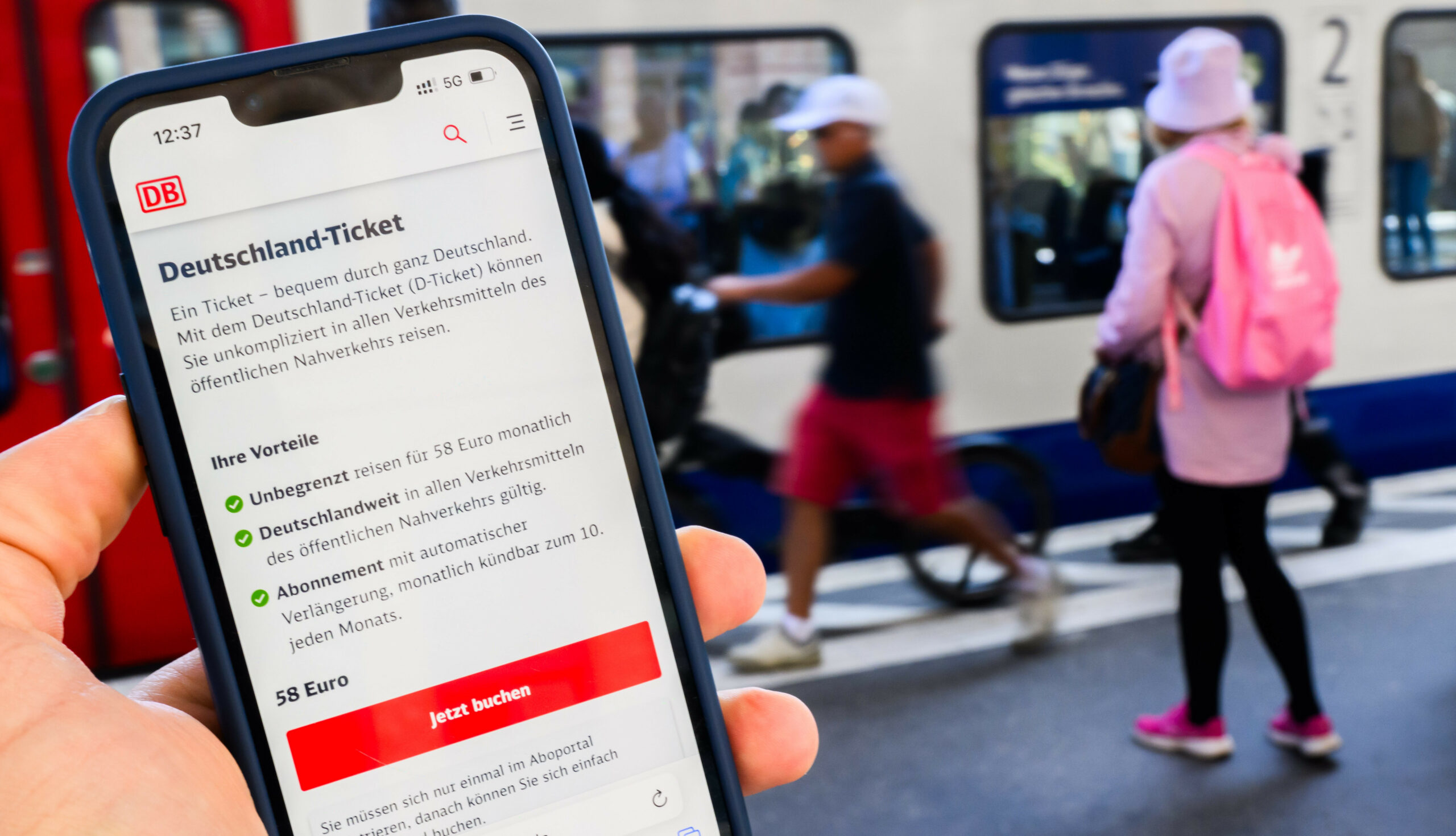 Eine Information zum Kauf des Deutschlandtickets ist auf dem Display eines Smartphones am Hauptbahnhof Hannover zu sehen.