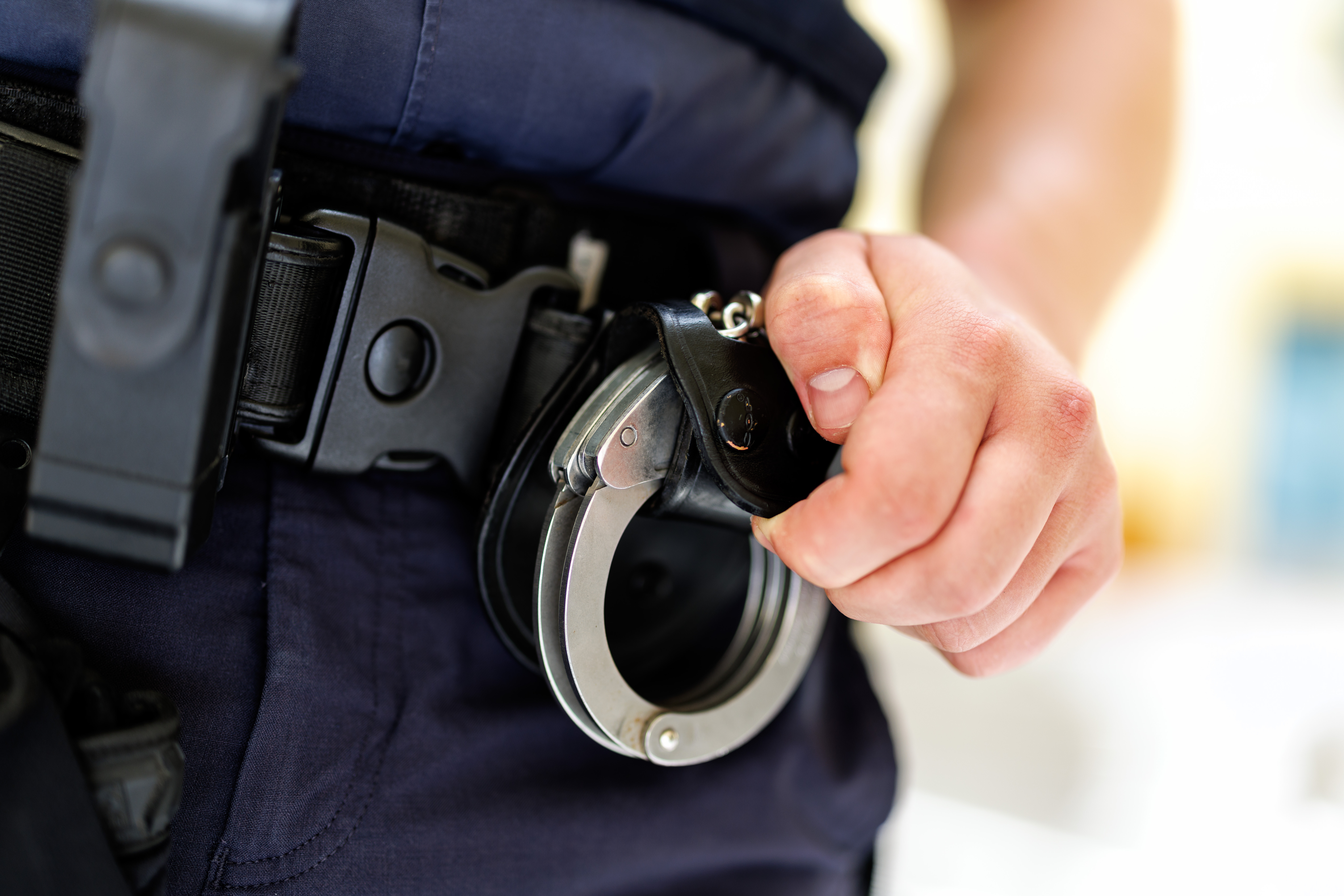 Ein Polizist hält Handschellen.