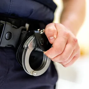Ein Polizist hält Handschellen.