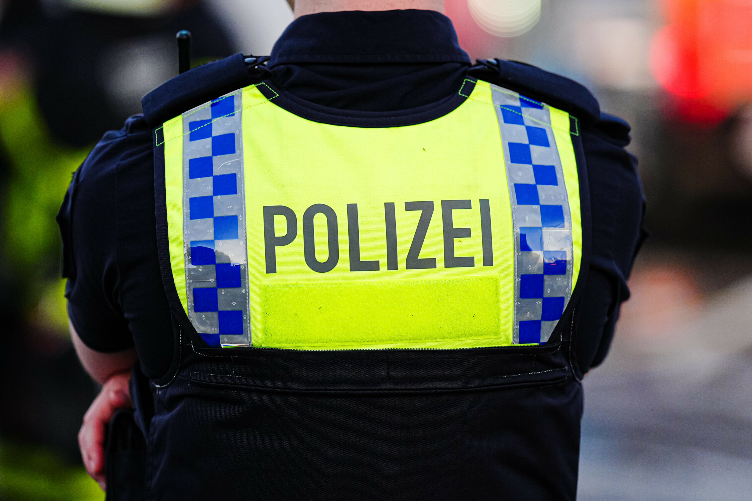 Ein Mensch in Polizeiuniform von hinten