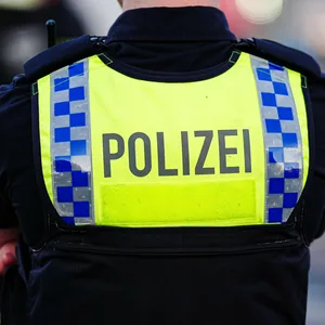 Ein Mensch in Polizeiuniform von hinten