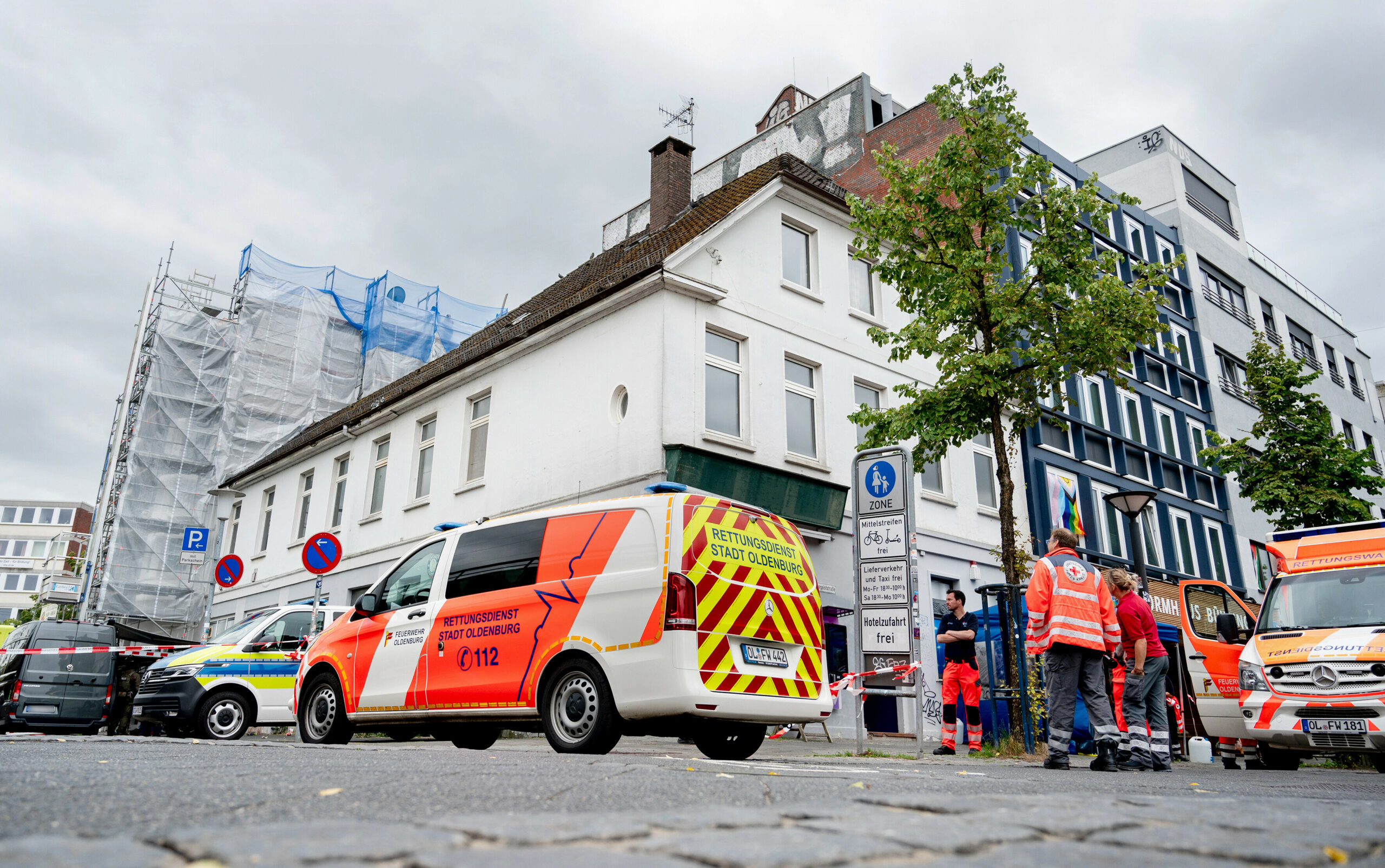 Einsatzfahrzeuge von Polizei und Feuerwehr stehen vor einem Haus in der Innenstadt.