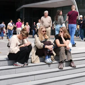 Besucherinnen und Besucher genießen am verkaufsoffene Sonntag auf dem Vorplatz des Einkaufscenters Westfield Hamburg-Überseequartier das gastronomische Angebot und das sonnige Wetter.