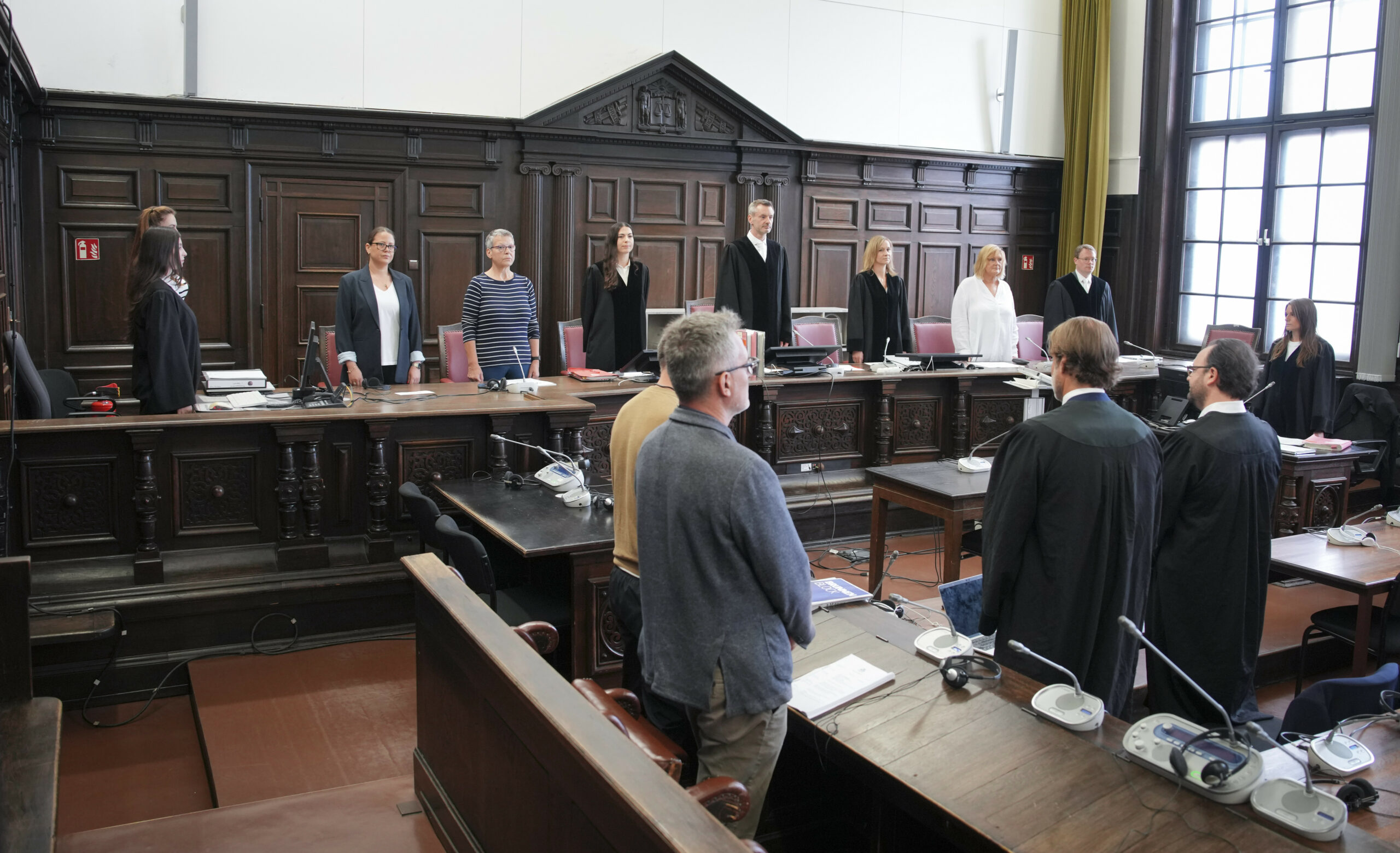 Der Angeklagte steht zu Beginn des Prozesses neben einem Dolmetscher für Albanisch