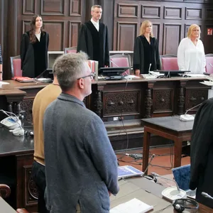 Der Angeklagte steht zu Beginn des Prozesses neben einem Dolmetscher für Albanisch