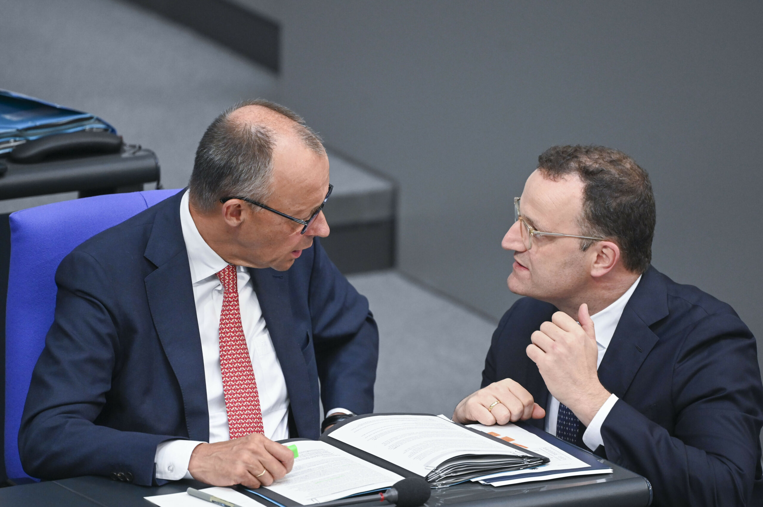 Friedrich Merz und Jens Spahn unterhalten sich im Bundestag