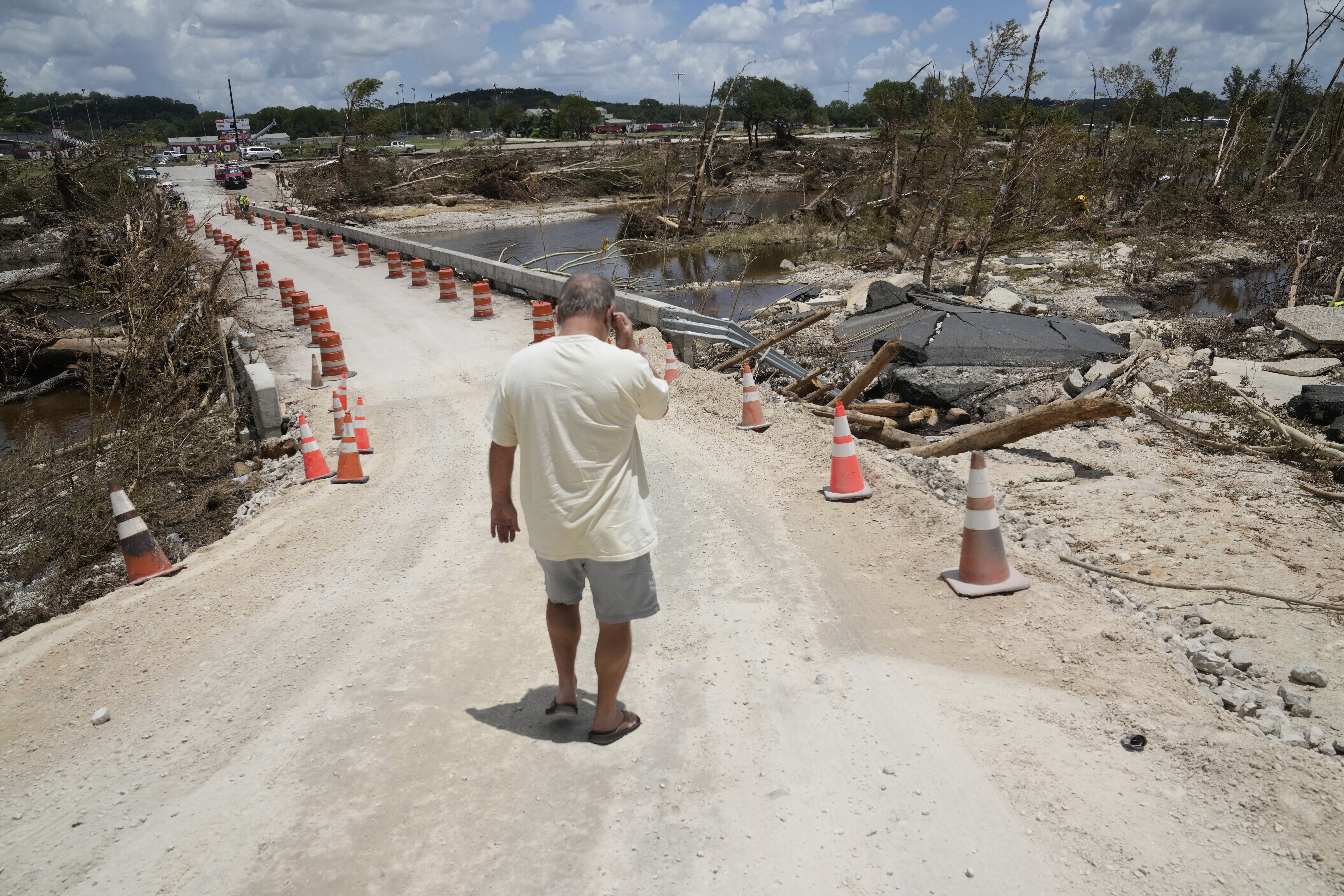 Ein Anwohner geht nach den Überschwemmungen in Kerrville die Brücke über den Guadalupe River entlang.