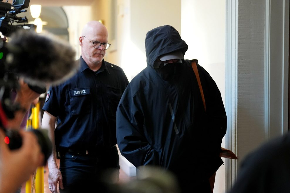 Ein Angeklagter wird in den Prozesssaal geführt.
