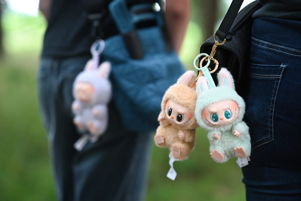 Labubus hängen an Umhängetaschen.