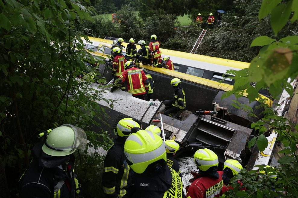 Rettungskräfte auf einem entgleisten Zug