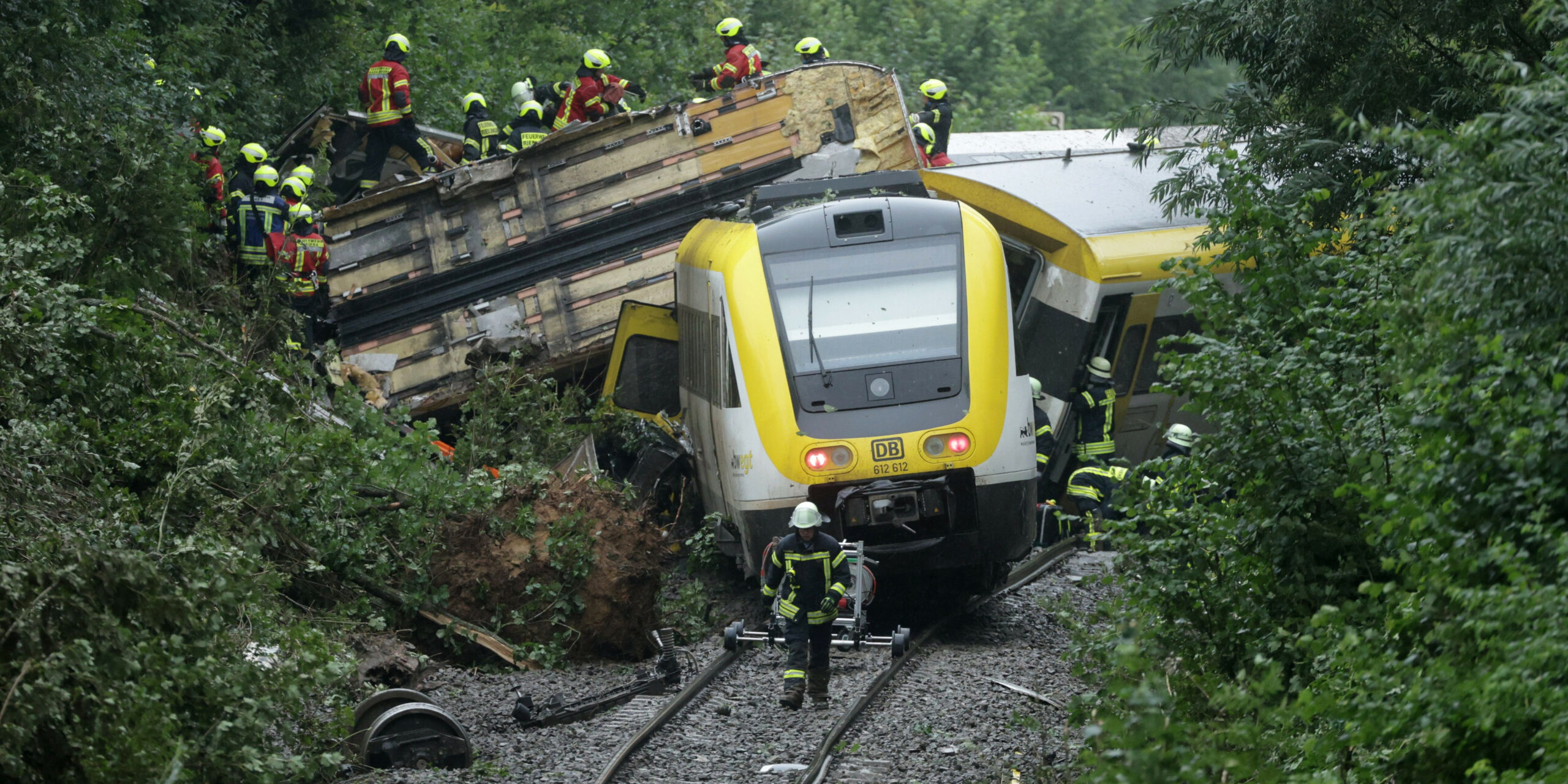 Rettungskräfte stehen vor dem entgleisten Zug.